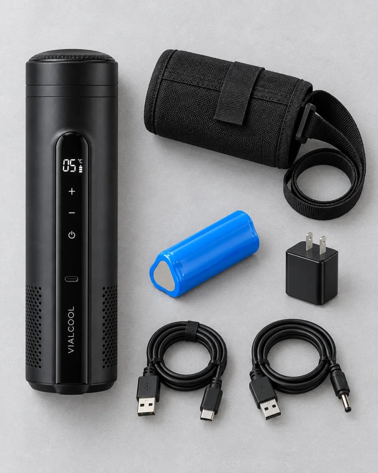 Everything in the VialCool Ultra box laid out on a grey table: the cooler, a carry pouch with shoulder strap, one rechargeable battery, a US wall adapter, a USB-C charging cable and a USB-A to barrel-plug cable
