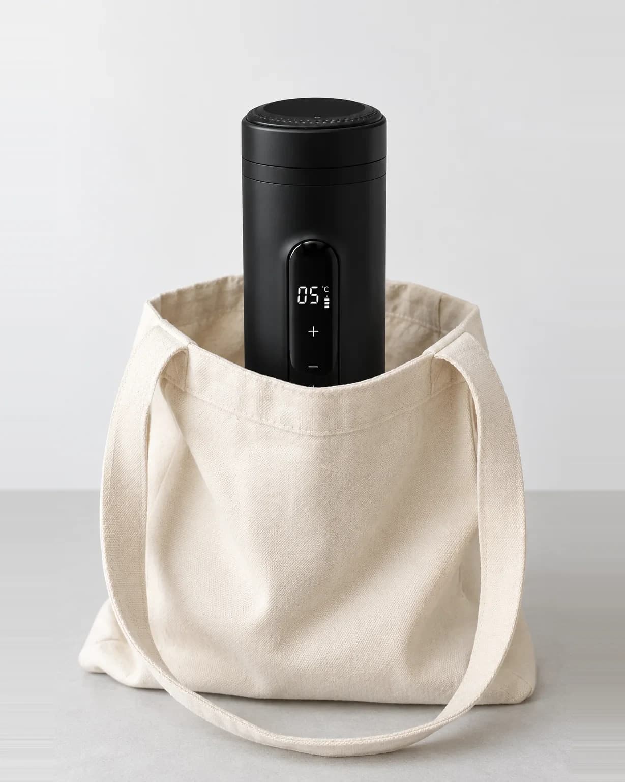 The cooler standing upright in a canvas tote bag, the display reading 05°C